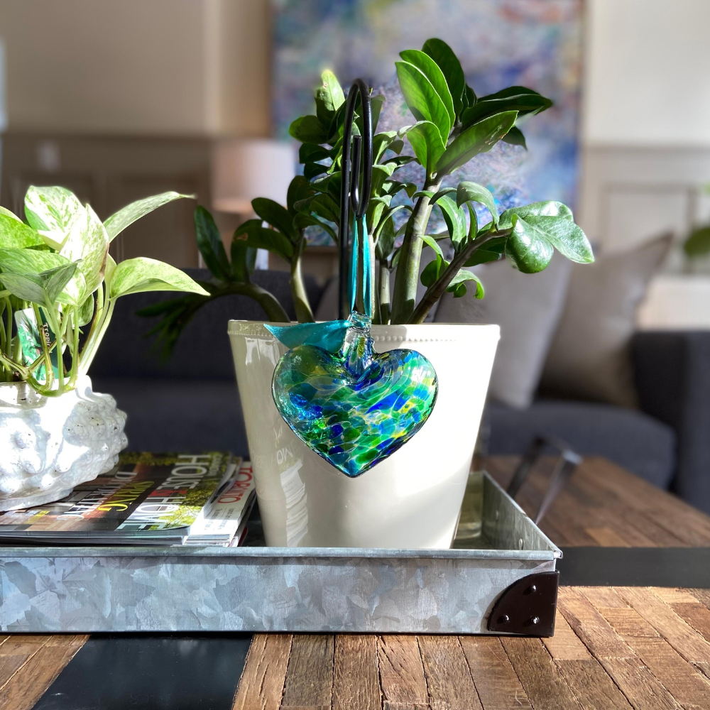 Oceania Multi Heart hanging from a green ribbon on a Small Shepherd's Hook Stake in a potted plant.