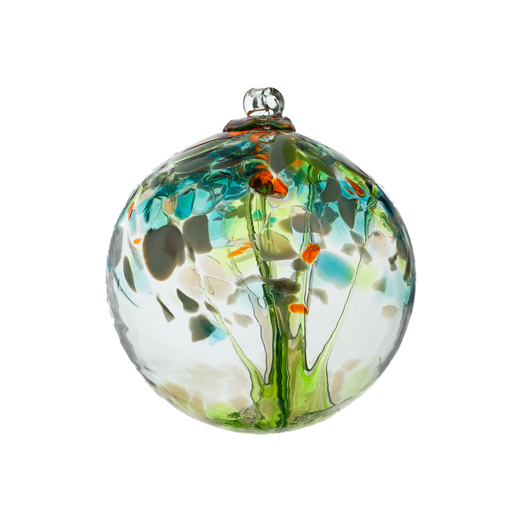 Clear glass orb with lime glass pulled through the middle and yellow, green, gold glitter and blue glass bits on top on a transparent background