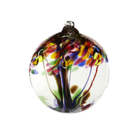 Clear glass orb with purple glass pulled through the middle and Yellow, Amber, Fuchsia, Purple, Brown and Green bits on top on a transparent background.